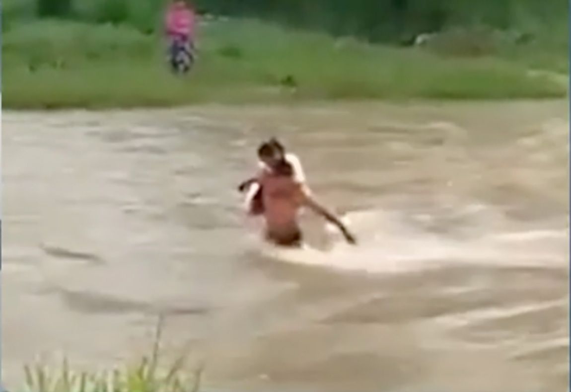 ▶ Un padre ayuda a su hija a cruzar el río para que vaya a la escuela